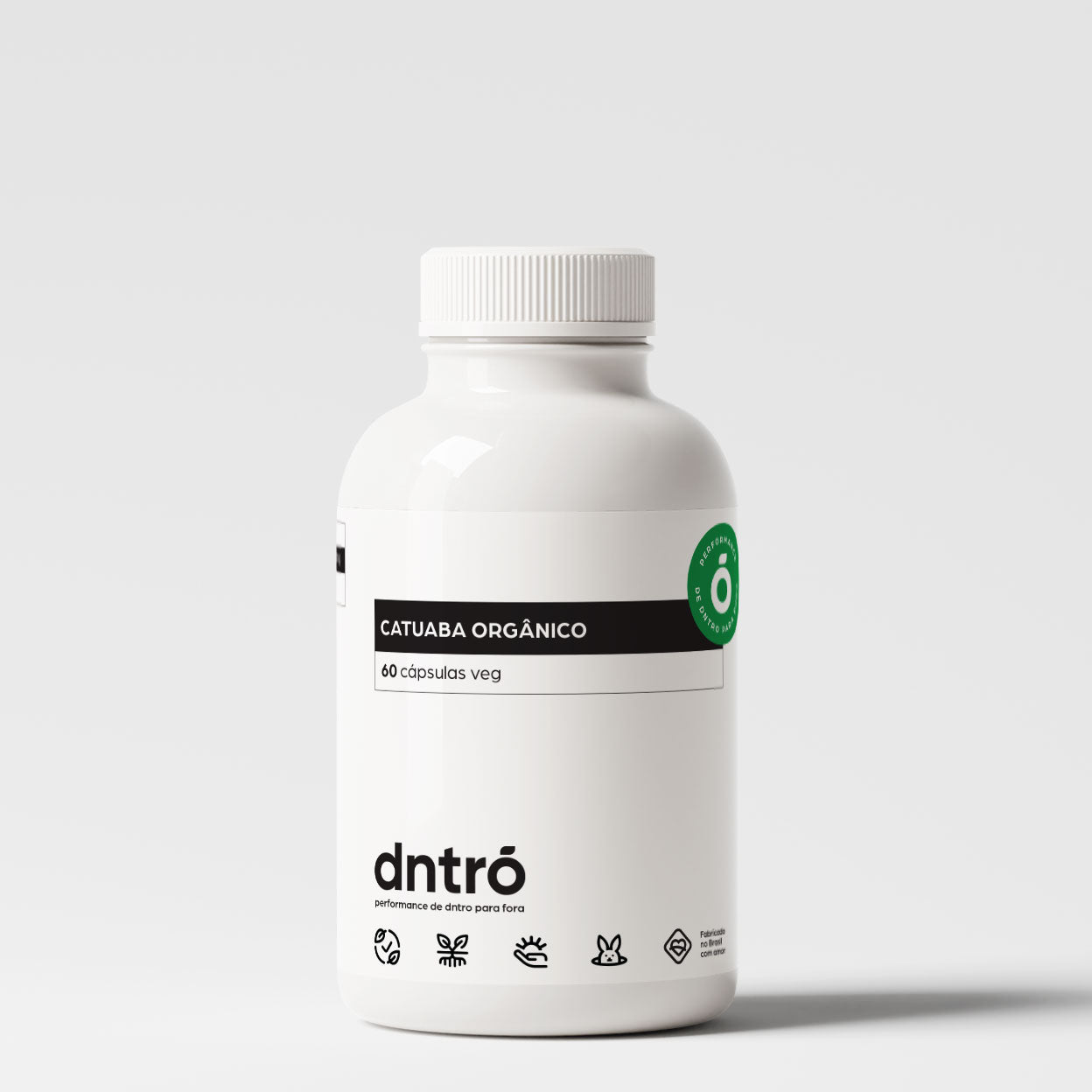 Frasco branco do suplemento DNTRO Catuaba Orgânico com 60 cápsulas veganas. Rótulo minimalista com faixa preta e selo verde "Performance de dentro para fora". Produto vegano, sem glúten, sem lactose e não testado em animais. Indicado para energia, libido e vitalidade natural.
