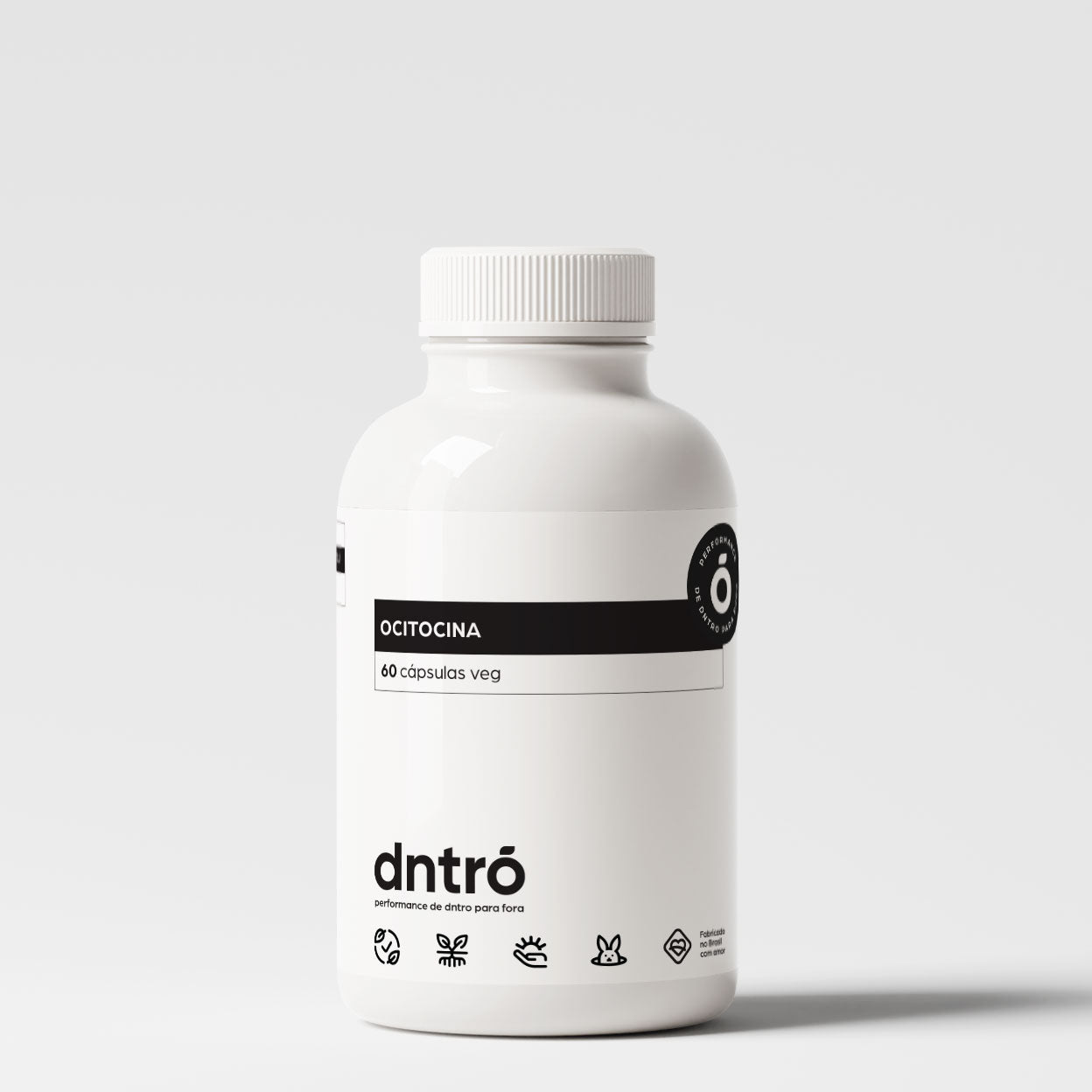 Frasco branco do suplemento DNTRO Ocitocina com 60 cápsulas veganas. Rótulo minimalista com selo preto “Performance de dentro para fora” e ícones que indicam produto vegano, sem glúten, sem lactose, cruelty-free e com ingredientes naturais. Suplemento voltado para bem-estar emocional, vínculos afetivos e equilíbrio hormonal.