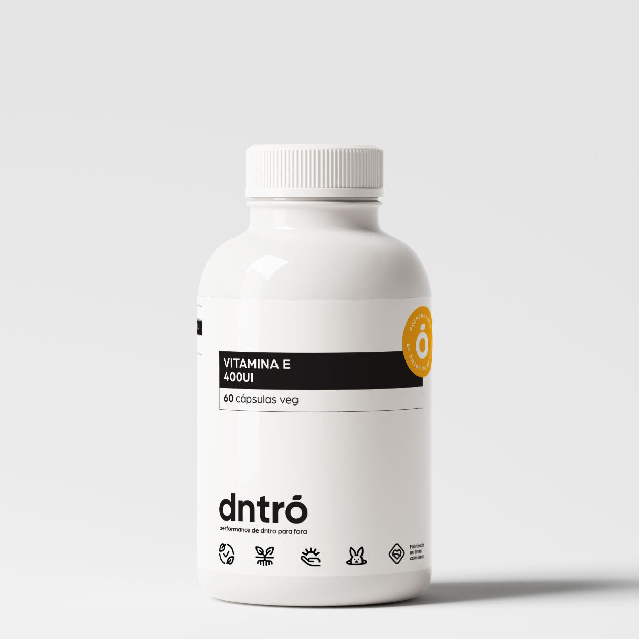 Frasco do suplemento DNTRO Vitamina E 400UI com 60 cápsulas veganas. Embalagem branca com faixa preta e selo laranja. Produto natural, vegano e livre de testes em animais, indicado para pele, imunidade e saúde celular.