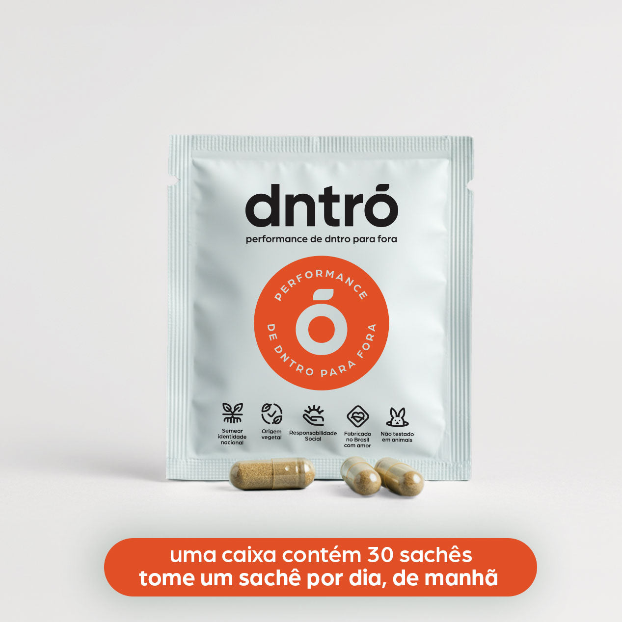 Imagem de um sachĂȘ do suplemento dntrĂł, com o texto âperformance de dntro para foraâ e um selo circular laranja indicando âperformance de dntro para foraâ. Abaixo do sachĂȘ, hĂĄ quatro cĂĄpsulas espalhadas. O sachĂȘ exibe Ăcones informando que o produto Ă© sem conservantes, de origem vegetal, recomendado para a saĂșde sexual, produzido com matĂ©rias-primas de qualidade e nĂŁo testado em animais. Na parte inferior, uma faixa laranja com a instrução: âuma caixa contĂ©m 30 sachĂȘs, tome um sachĂȘ por dia, de manhĂŁâ.